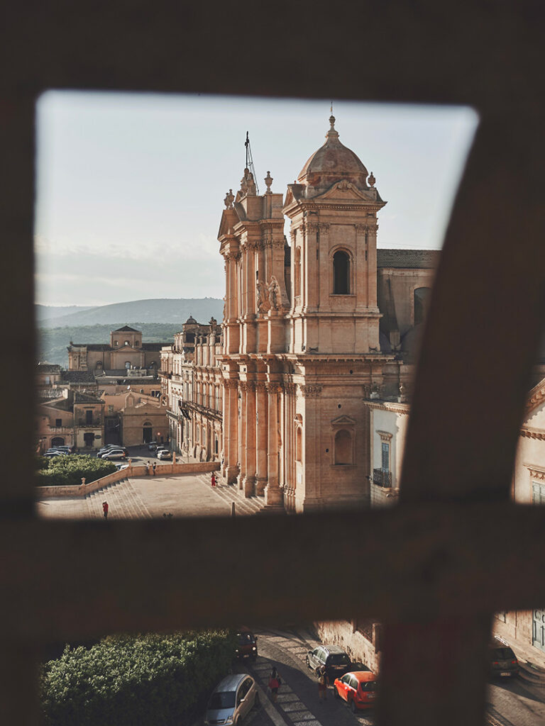 baroque cathedral of noto viewed from behind a grill