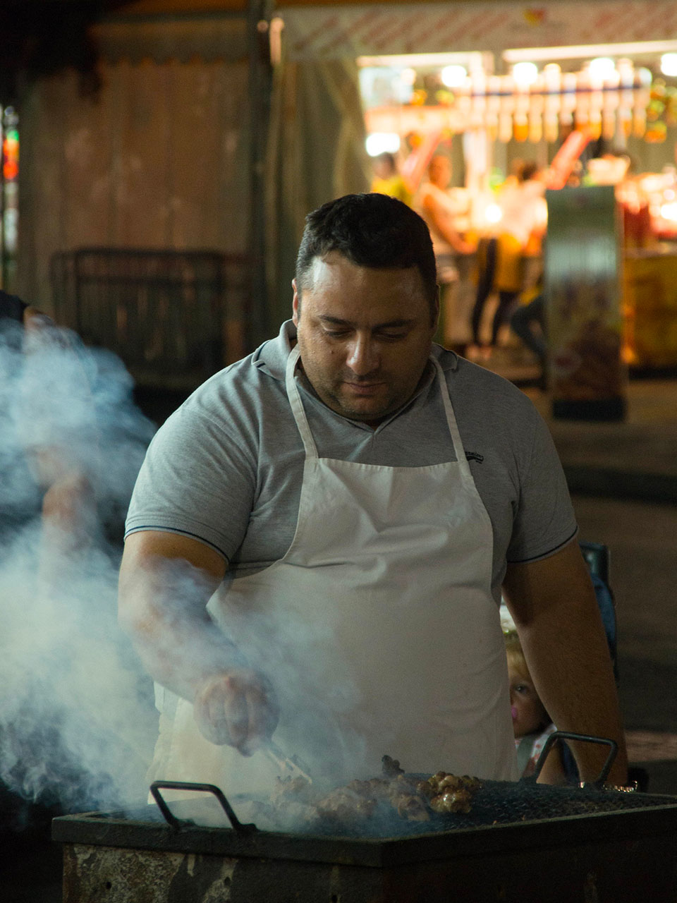 man roasting "stigliole" (Palermo street food based on lamb intestines)