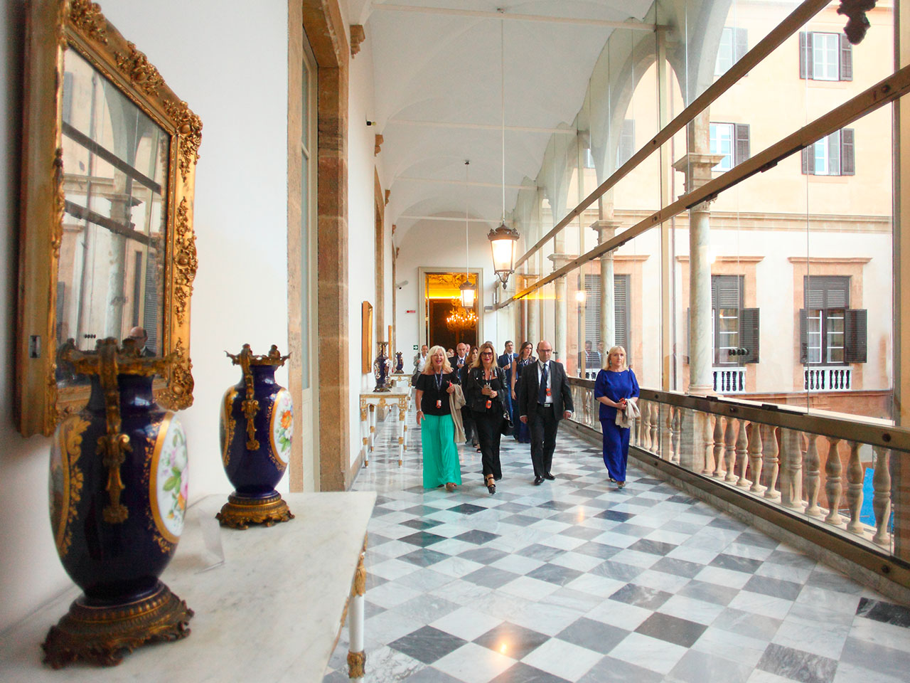 Event at the Royal Palace in Palermo, people walking along the external corridors