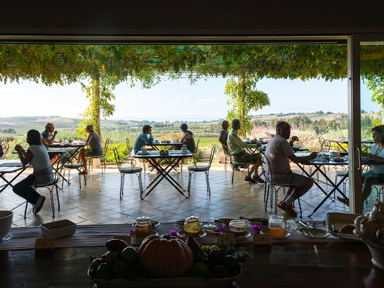 Terrace of the Foresteria Planeta with guests sitting at the tables
