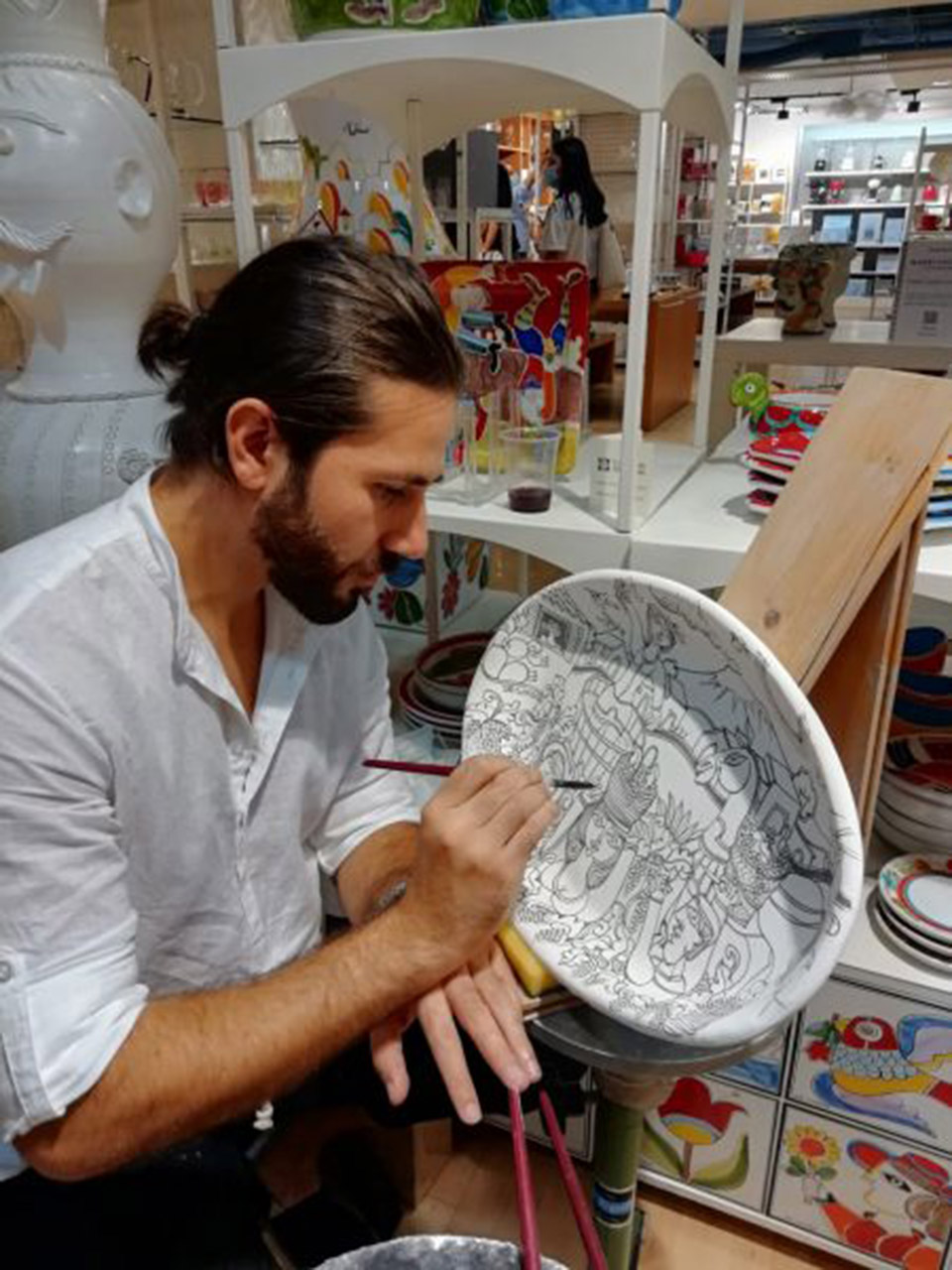 craftsman painting a ceramic plate