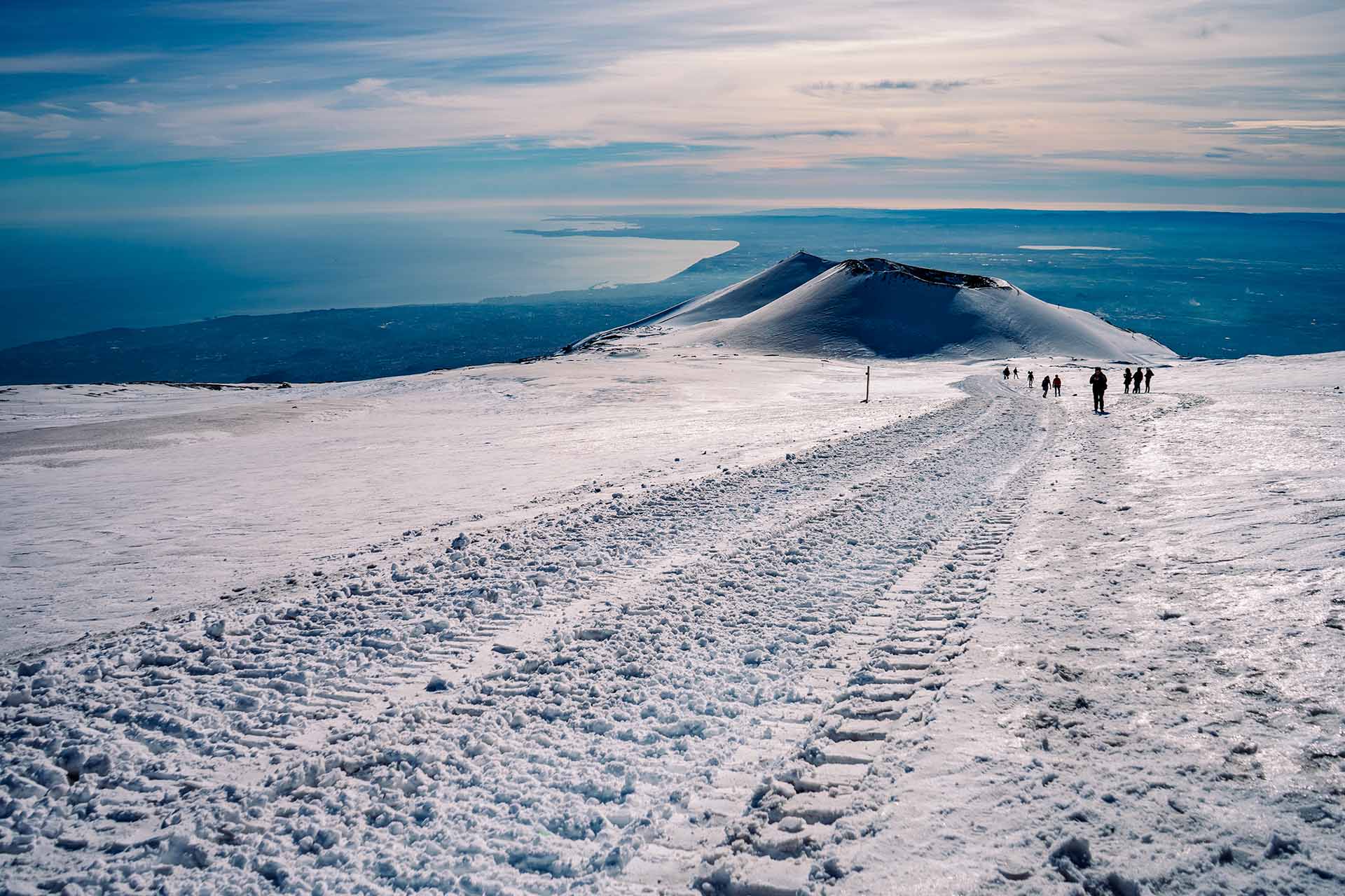 view of the coast from the top of snow-capped Mount Etna