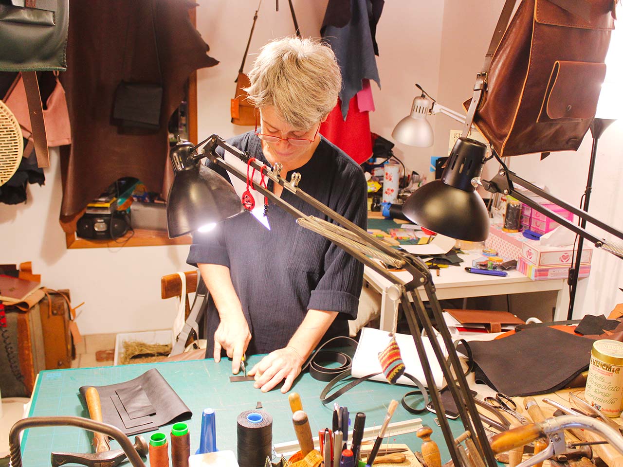 Kau, leather and leather shop in Palermo. View of a woman working in the laboratory