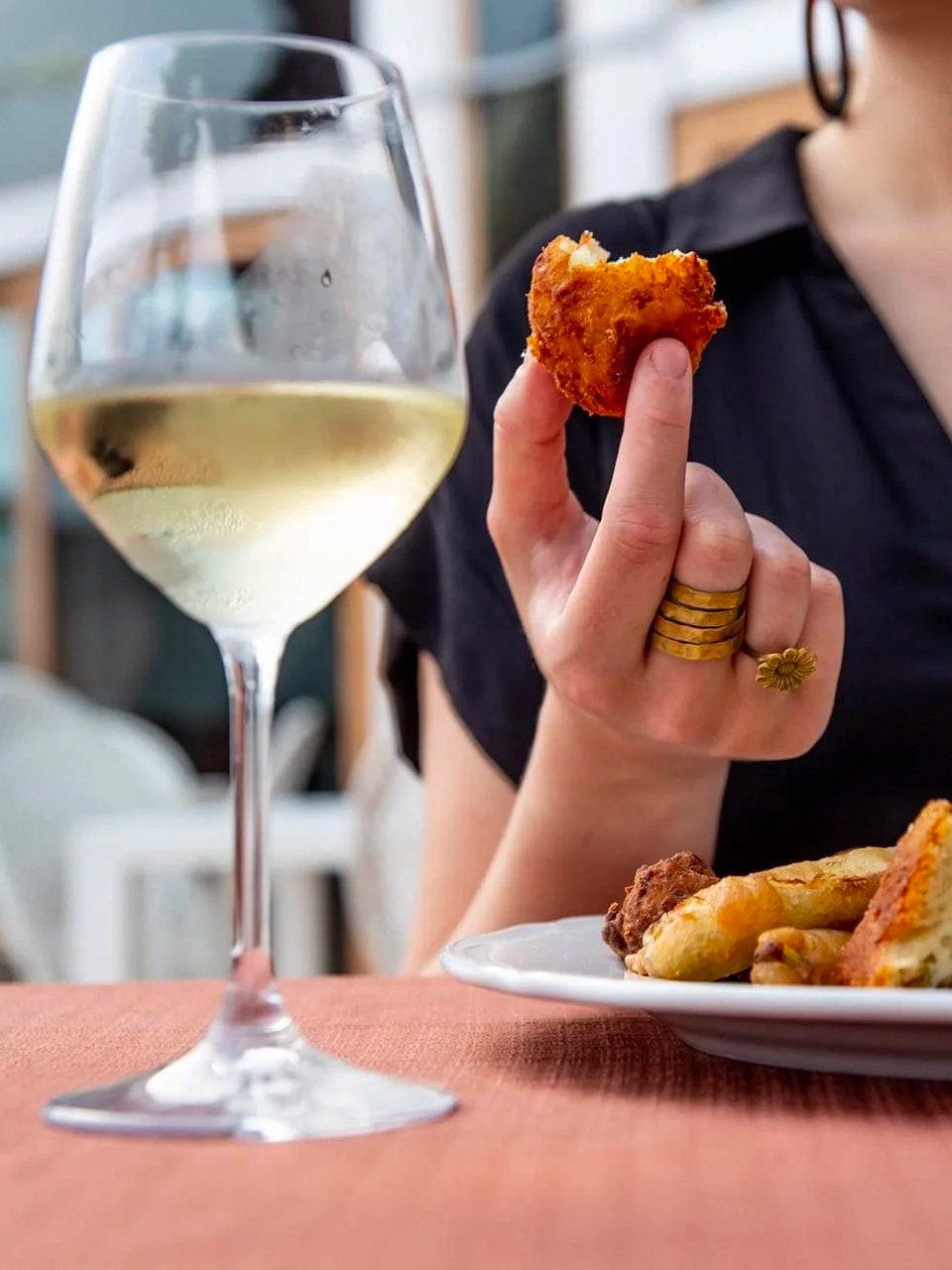 woman having an aperitif in Palermo, with wine and fried food