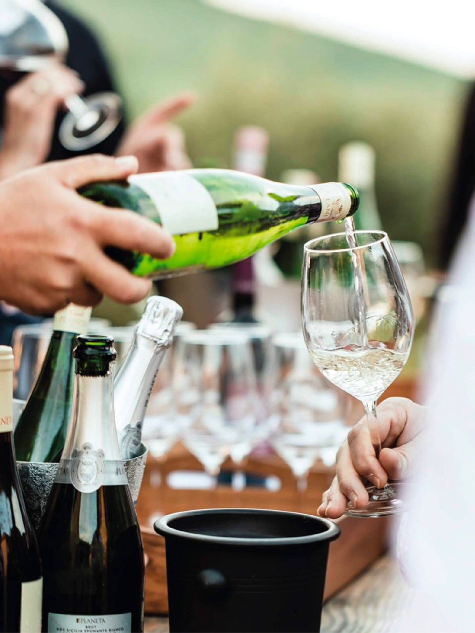 hand pours wine into a glass during a tasting