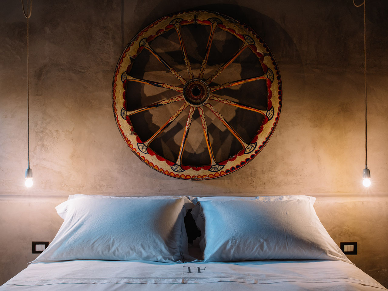 bedroom with a Sicilian cart wheel in the Fessina estate in Castiglione di Sicilia